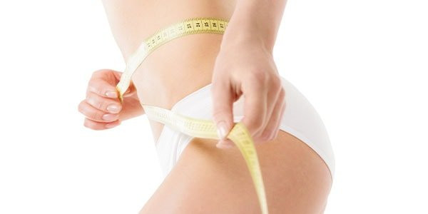 Frau legt Maband um ihren Bauch